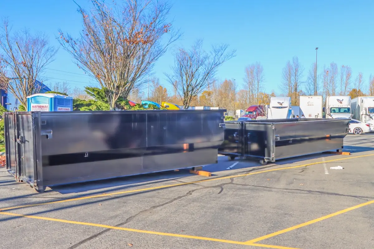 Professional dumpster rental service with roll-off container on residential driveway in Penn Forest